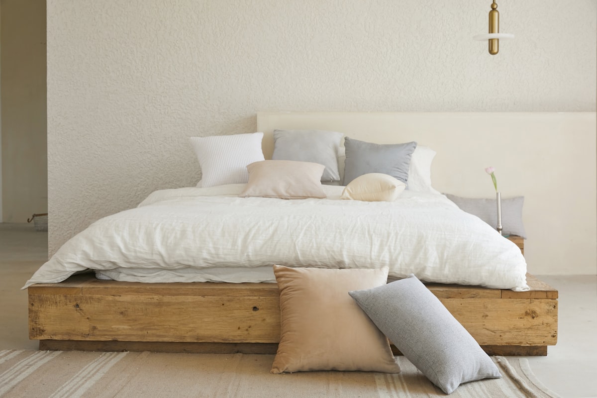 Cozy bedroom with bed frame, mattress, nightstand, and layered bedding in neutral tones